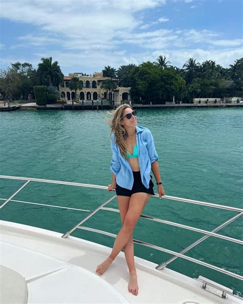 A Woman Standing On The Back Of A Boat