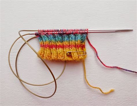 An Orange Yellow And Red Knitted Object On A White Surface With