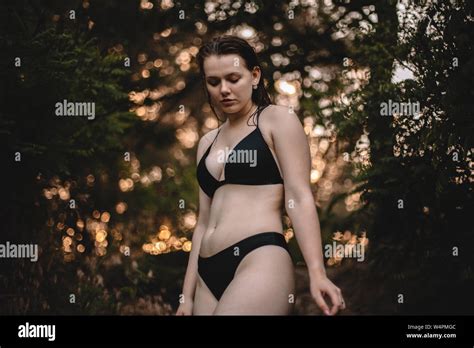 Sensual Woman In A Bikini Standing Against Trees In Forest Stock Photo Alamy