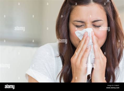Brunette Blowing Nose Into Tissue Stock Photo Alamy