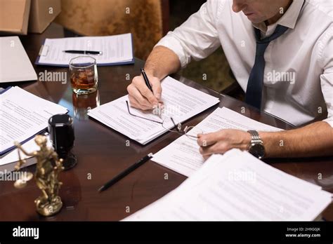 Hands Of Serious Mature Businessman Pointing At Contract While Reading