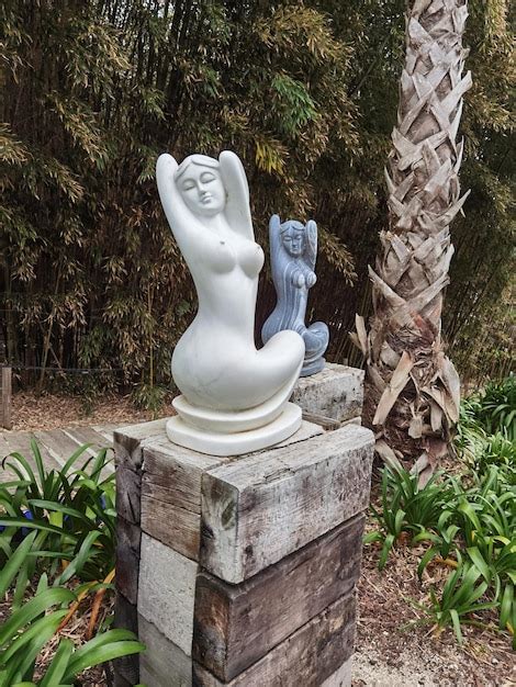 Premium Photo Two Marble Statues Of Naked Women Sitting In A Green Garden