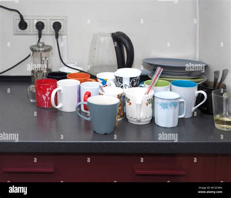 Bunch of various mugs and dishware on a top of office desk Stock Photo - Alamy