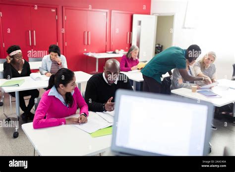 Community College Students Working Together Studying In Classroom