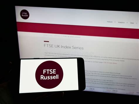 Person Holding Smartphone With Logo Of British Company FTSE Russell