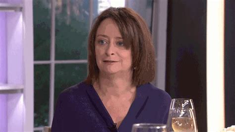 a woman sitting at a table with two wine glasses