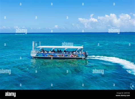 Tourists On A Glass Bottom Boat Tour Over The Coral Reef At Lady