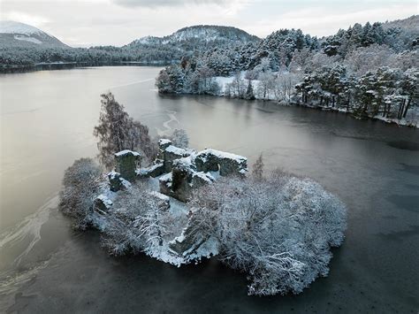 Aerial View Of Ruined Castle In Snow On Loch An Eilein In Cairngorms