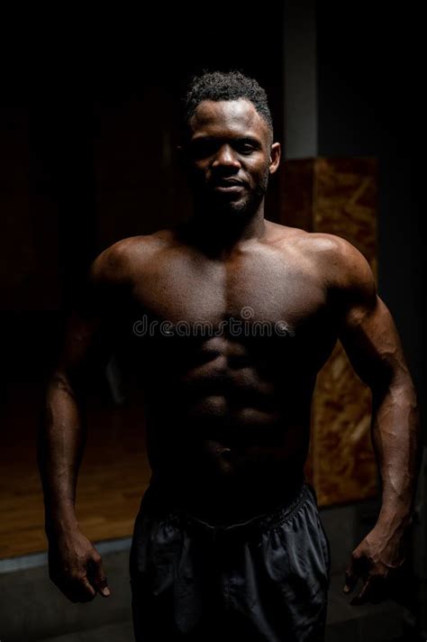 Portrait Of An African American Man With A Naked Torso In A Dark Studio