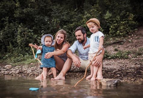 Una Familia Joven Con Dos Ni Os Del Ni O Al Aire Libre Por El R O En