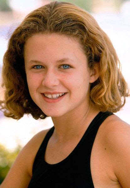 A Close Up Of A Person Wearing A Black Shirt And Smiling At The Camera