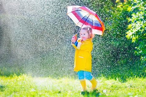 Funny toddler with umbrella playing in the rain 831339 Stock Photo at Vecteezy