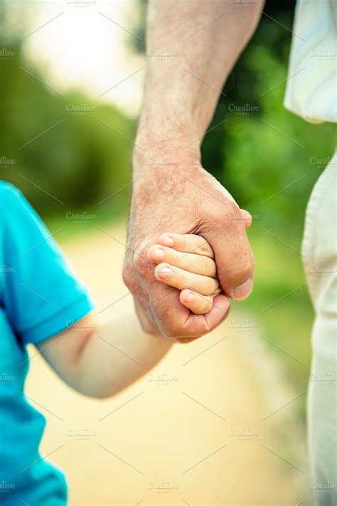 Child and senior man holding hands stock photo containing child and young | People Images ...