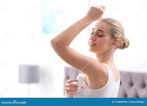 Beautiful Young Woman Applying Deodorant In Bedroom Stock Photo Image