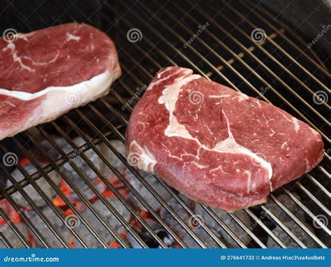 Raw Rib Eye Steak On Grill Grate Over Charcoal Grill Preparing Beef