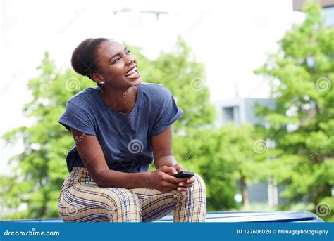 Beautiful Young African American Woman Laughing With Mobile Phone