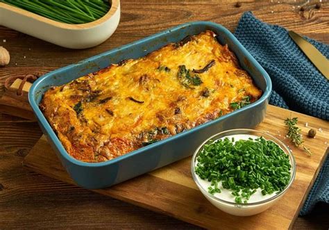 A Casserole Dish On A Cutting Board With Green Onions