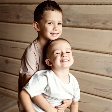 El niño abraza a su hermano pequeño el hermano mayor sostiene al menor