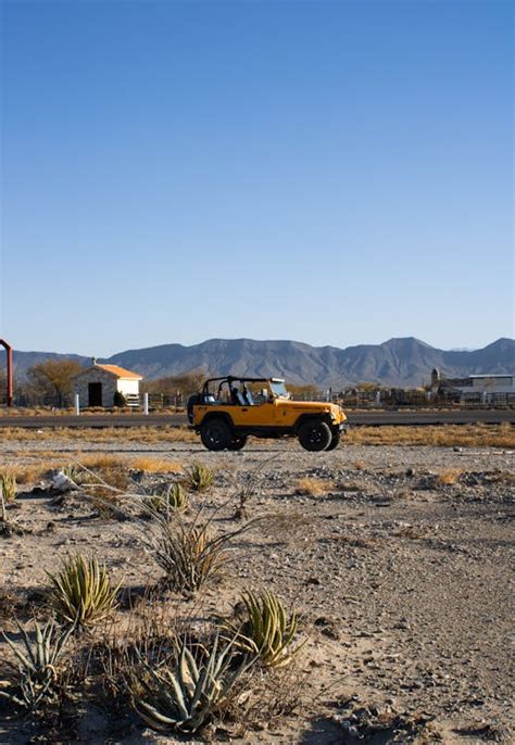 Yellow Wrangler Jeep on Dirt Road · Free Stock Photo