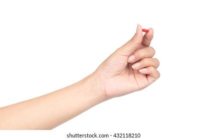 Hand Holding Pill Between Thumb Forefinger Stock Photo