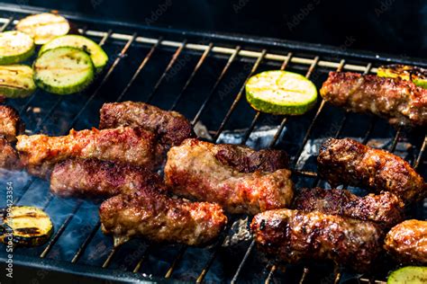 Grilling Meat Rolls Called Mici Or Mititei With Vegetables On Char