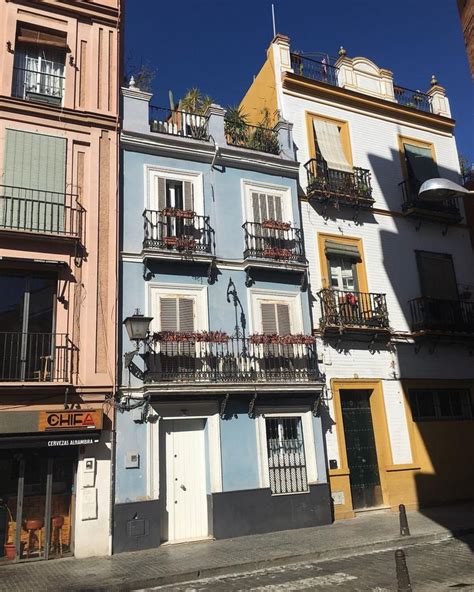 Several Different Colored Buildings With Balconies On Top