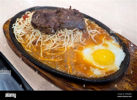 Taiwanese Style Special Sizzling Beef Steak With Noodles Egg And Sauce On An Hot Iron Board In