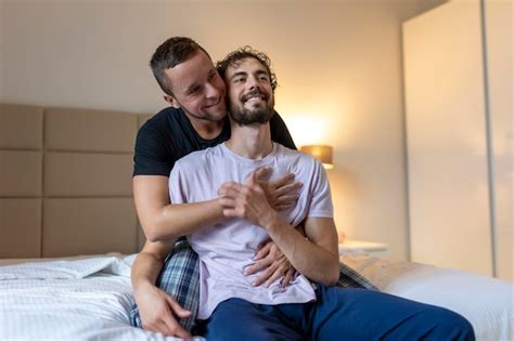 Pareja gay abrazándose con los ojos cerrados dos jóvenes amantes masculinos tocándose la cara