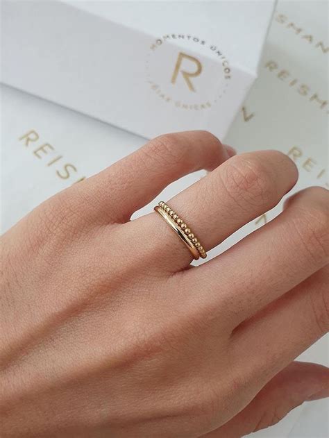 A Woman S Hand With A Gold Ring On Her Left Hand And A White Box In The