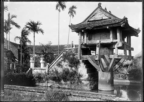 an old black and white photo of a building on the side of a river with ...