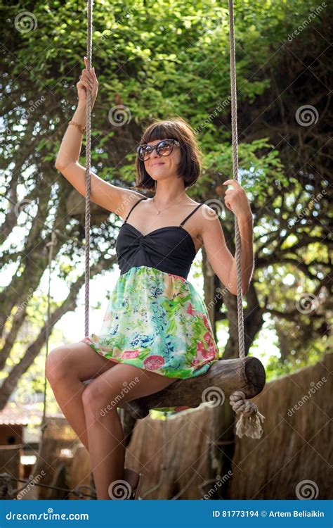 Sensual Tender Girl Sitting On A Swing Wearing Beautiful Dress She Has