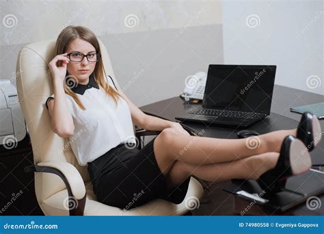 De Sexy Bedrijfsvrouw Zit Met Haar Voeten Op Het Bureau Stock Foto