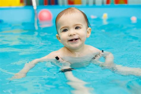 Um Menino De Anos Aprende A Nadar Em Uma Piscina Um Treinador