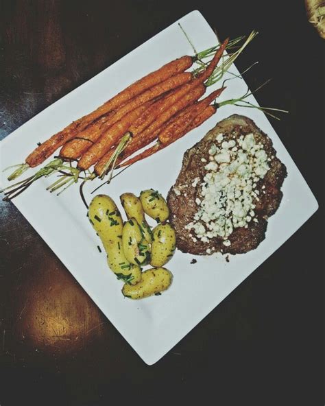 Montreal Steak Topped With Blue Cheese Crumbles And Sided With Chive Butter Fingerling Potatoes