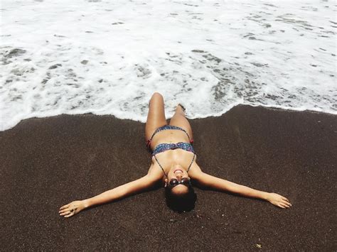Premium Photo High Angle View Of Woman In Bikini Lying On Sea Shore