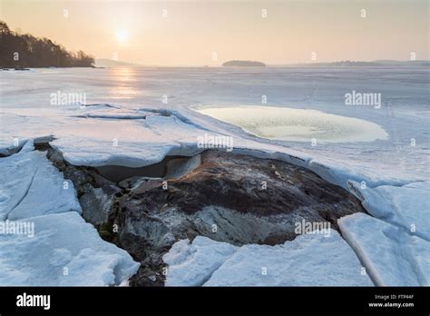 Rock Under Cracked Ice At A Frozen Lake In Finland In The Spring At