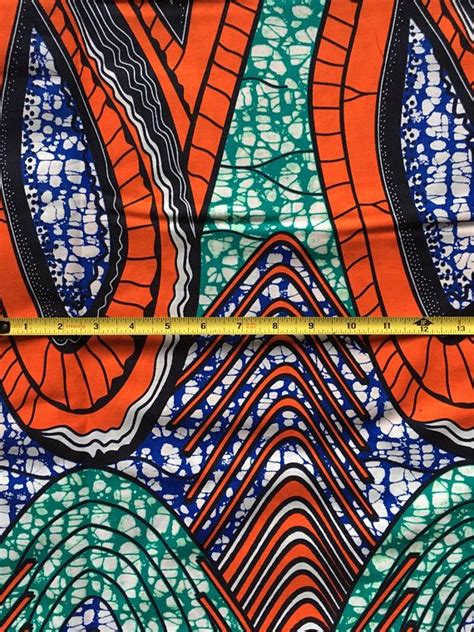 An Orange Blue And Green Abstract Print Fabric With Wavy Lines On The