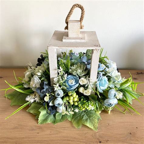 A Bouquet Of Flowers Is Sitting On A Wooden Table Next To A Small White Box