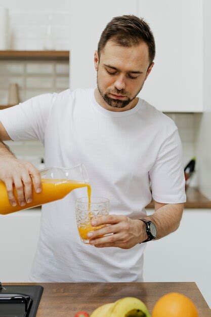 Premium Photo Man Pouring Orange Juice Into A Glass