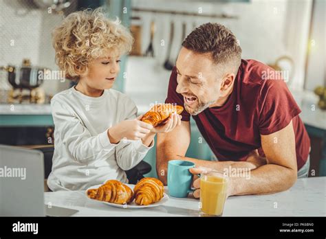 Curly Blonde Haired Boy Sharing Croissant With His Father Stock Photo Alamy