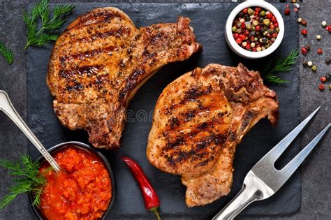 Bife Grelhado Cebola E Molho De Tomate Numa Prancha De Madeira