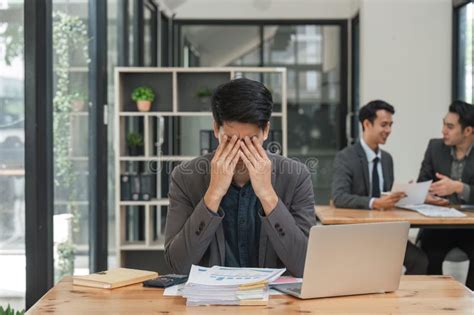 Business Man At Work On His Laptop While Suffering From A Headache And Anxiety With A Working