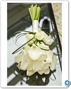 A Bouquet Of White Flowers Sitting On Top Of A Glass Table