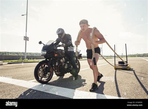 Sled Push Man Pushing Weights Workout And Competing With Motorcycle