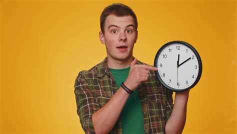 Premium Photo Portrait Of Woman Holding Alarm Clock Against Yellow