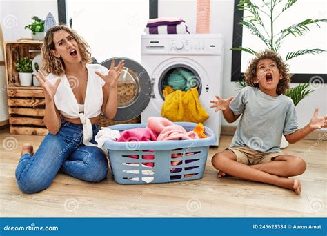 Young Woman And Son Putting Dirty Laundry Into Washing Machine Crazy