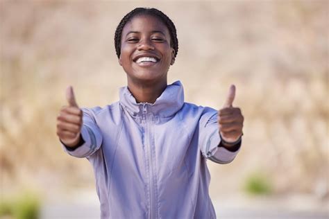 Polegares para cima mulher negra e vencedora de sucesso e motivação