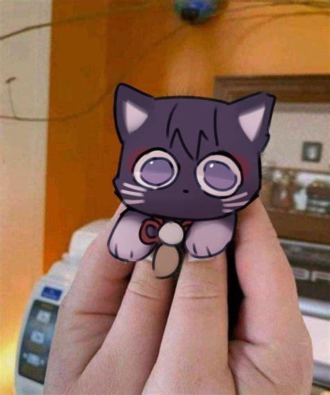 A Person Holding Up A Small Purple Cat Sticker