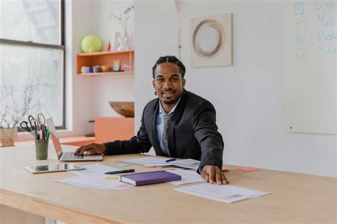 Smiling Man Sitting at his Desk Working in the Office · Free Stock Photo