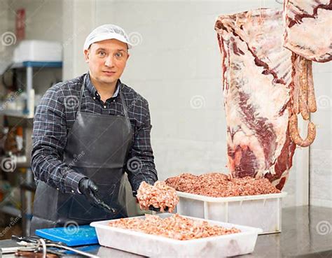 Male Butcher Holding Chunk Of Minced Beef In Butchery Stock Photo